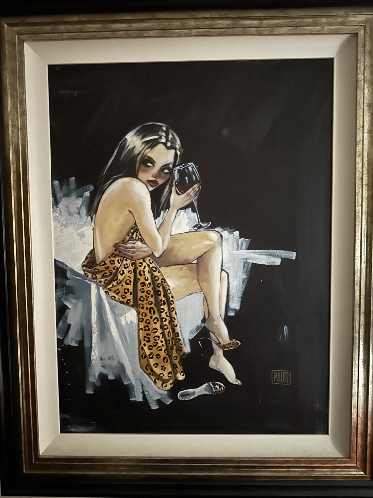 Cami, an artwork by Todd White, depicts an attractive brunette draped in an animal print throw, holding a glass of red wine. She is seated in a contorted pose with one shoe on and one off, surrounded by loose white strokes against a predominantly black background.