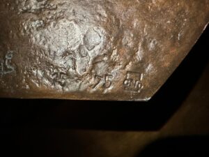 close-up view of a bronze sculpture with engraved markings by artist Vera Borghgraef