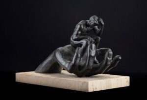 sculpture depicting a large hand cradling a contemplative human figure