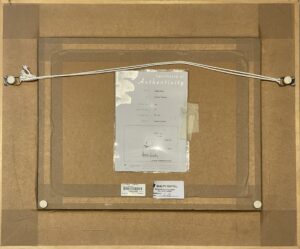 backside of framed artwork with label and hanging wire