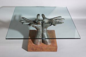 artistic table with sculpted hands and glass top