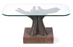 sculptural glass table supported by bronze hands