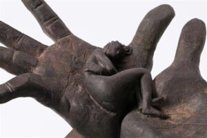 bronze sculpture of a reclining figure cradled in open hands