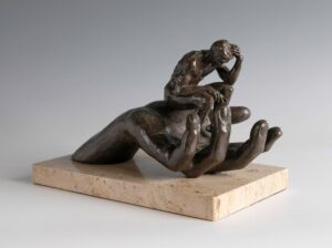 bronze sculpture of a large hand supporting a small person deep in thought