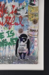 Colourful artwork by Mr. Brainwash featuring graffiti-style text and a monkey holding a sign.