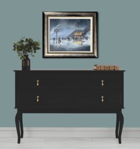 framed artwork titled 'You Don’t Know How Much I Miss You' by Jeff Rowland hanging above a black dresser with books and a plant