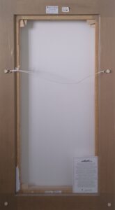 back view of a framed canvas with wiring and labels
