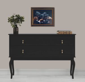 interior scene with framed artwork above a black dresser