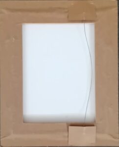 back of a framed artwork with brown paper and hanging wire