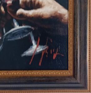 close-up of a framed artwork showing a hand holding a wine glass