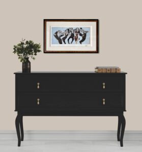 artwork titled 'Rounds On Me' by Todd White hung above a black dresser