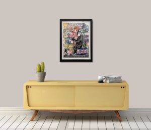 colourful Mr. Brainwash artwork titled 'God Save The Queen' displayed on a wall above a yellow console table with plants