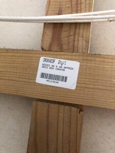 back of a canvas frame with a label indicating the artwork title and artist names