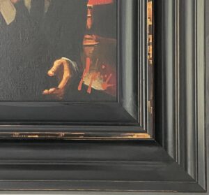 close-up of a framed painting showing a hand and abstract elements