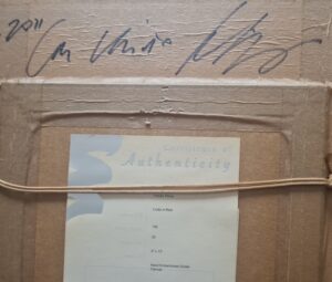 back of a painting with artist's signature and certificate