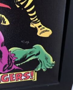 close-up of a comic book artwork featuring parts of superhero costumes with a visible signature and number.